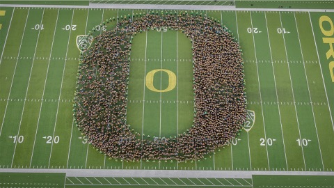 An aerial view of students forming the O logo on the Autzen Stadium football field